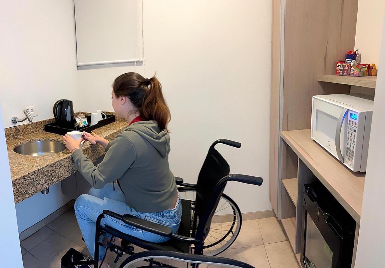 מלון סאו פאולו Radisson Oscar Freire מראה חיצוני תמונה A disabled woman in a wheelchair using a microwave oven